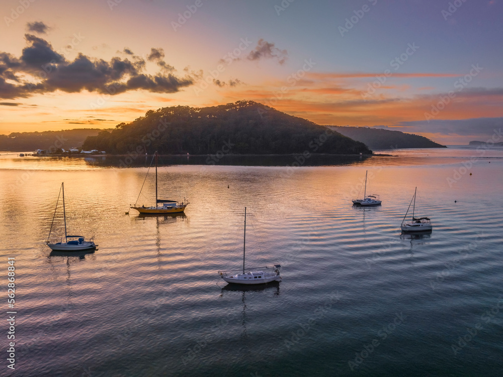 Aerial sunrise waterscape with boats and scattered clouds