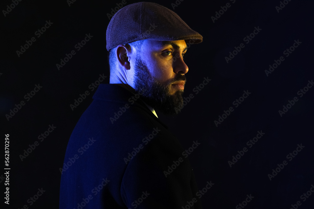 Silhouette of young bearded man in cap on dark background Silhouette of young bearded man in cap on dark background