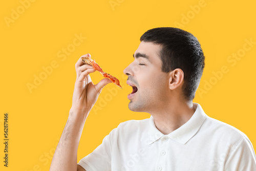 Young man eating tasty pizz...