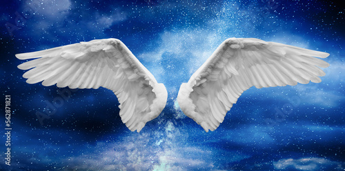 Angel wings with a background made of the sky covered with white clouds and Milky Way stars at night