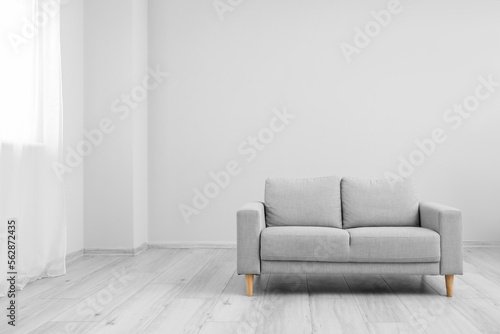 Interior of living room with grey sofa near window