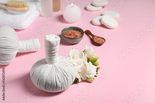 Herbal massage bags and other spa products on pink background  space for text