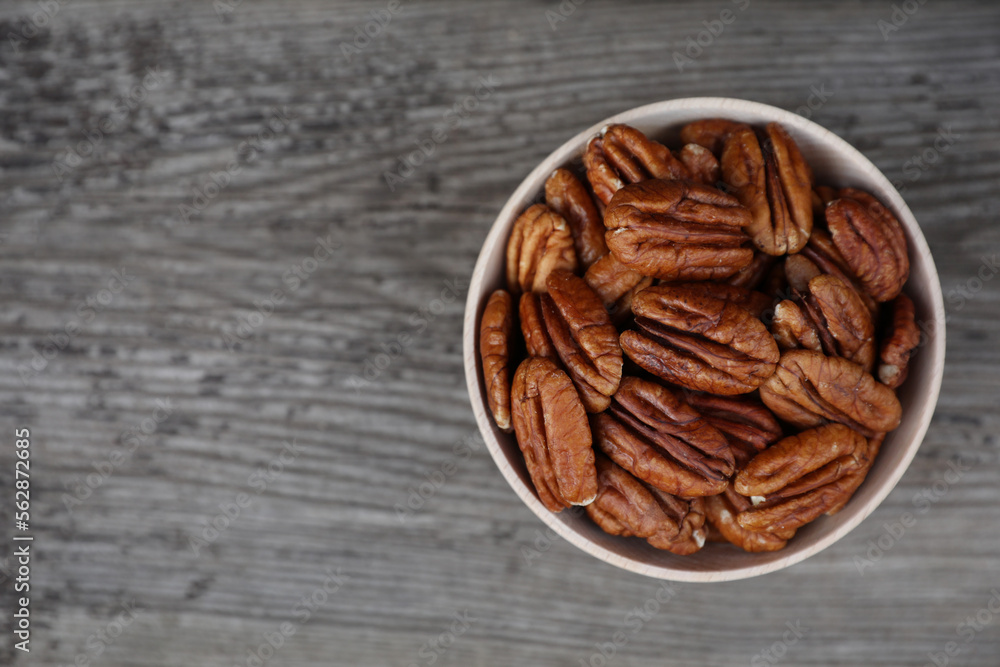 Tasty pecan nuts on grey wooden table, top view. Space for text Tasty pecan nuts on grey wooden table, top view. Space for text