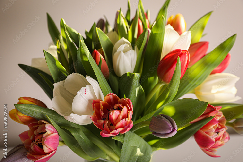 Beautiful bouquet of colorful tulips on beige background, closeup Beautiful bouquet of colorful tulips on beige background, closeup