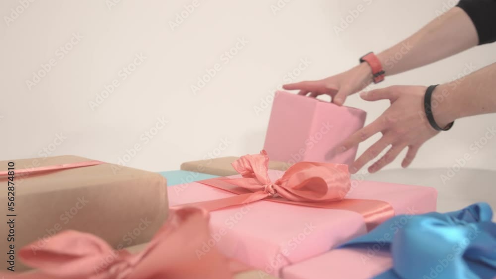 Hands close-up disassemble packed boxes with gifts at end there is white background to copy space. Theme of craft cardboard cube packed by yourself for birthday event or Christmas surprise party. Hands close-up disassemble packed boxes with gifts at end there is white background to copy space. Theme of craft cardboard cube packed by yourself for birthday event or Christmas surprise party.