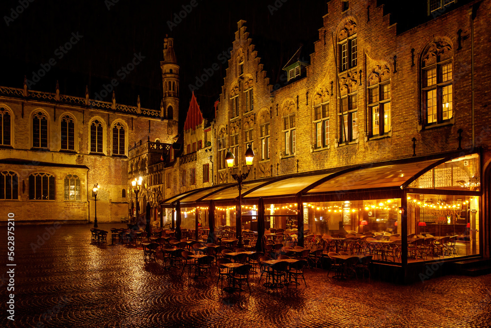 Restaurant with a terrace in the old Europe town square on a rainy night.