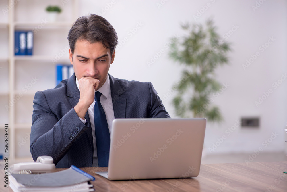 Young male employee working in the office Young male employee working in the office