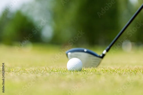 Close-up of the white golf ball on a stand on a green field