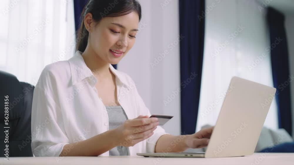 Young asian woman makes online banking payments through the internet from bank card on computer laptop. Shopping online on notebook with credit card Young asian woman makes online banking payments through the internet from bank card on computer laptop. Shopping online on notebook with credit card