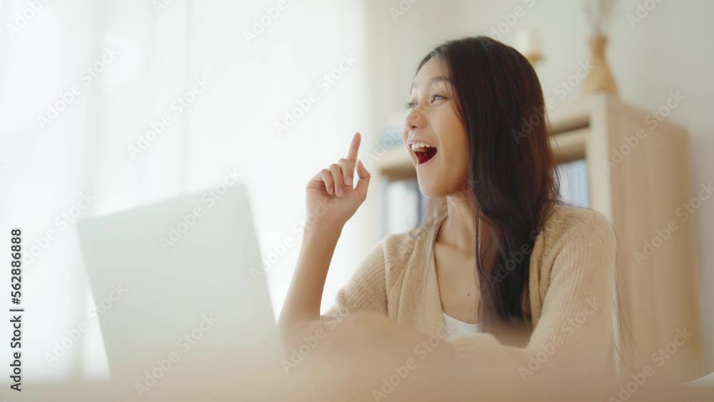 Young asian woman working on computer laptop on desk in living room at home Young asian woman working on computer laptop on desk in living room at home