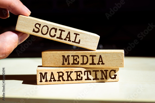 Closeup on businessman holding a wooden blocks with text SOCIAL MEDIA MARKETING, business concept