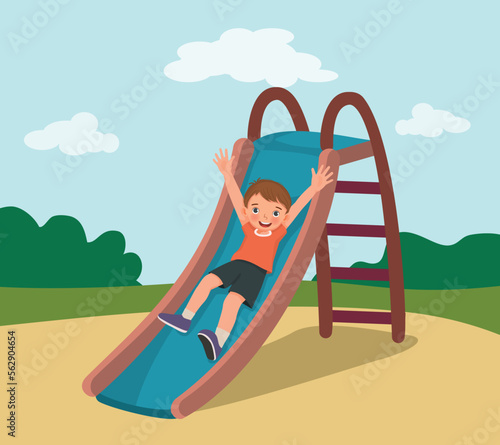 Cute little boy sliding down on slide in the playground 