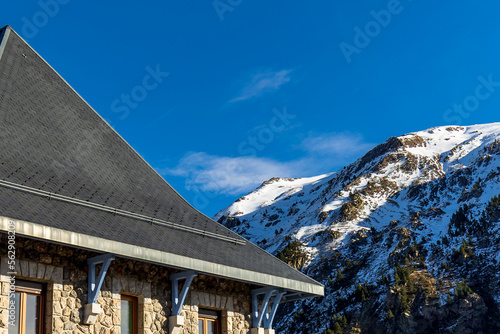 Top of a mountain house in Spain with a snow-capped mountain in the background.