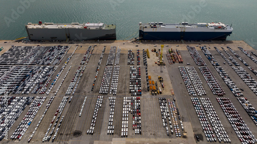 Roll-on Roll-of ship loading new cars line up . Automotive container carriers floating in sea,