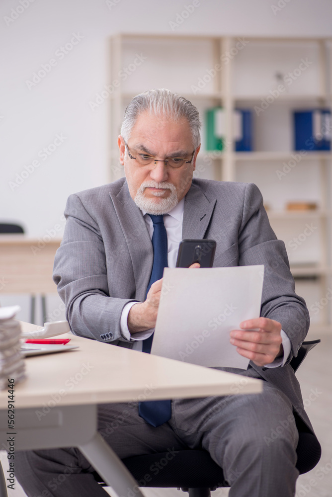 Old male employee working in the office Old male employee working in the office