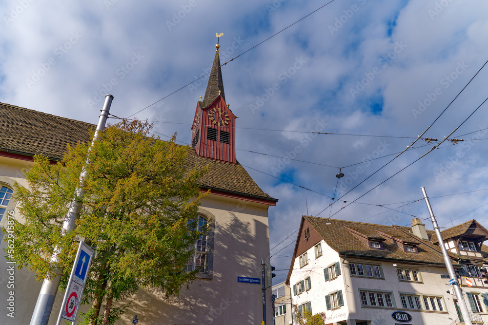 Old protestant church with historic house with restautrant at district Fluntern at City of Zürich on a blue cloudy autumn day. Photo taken December 8th, 2022, Zurich, Switzerland.