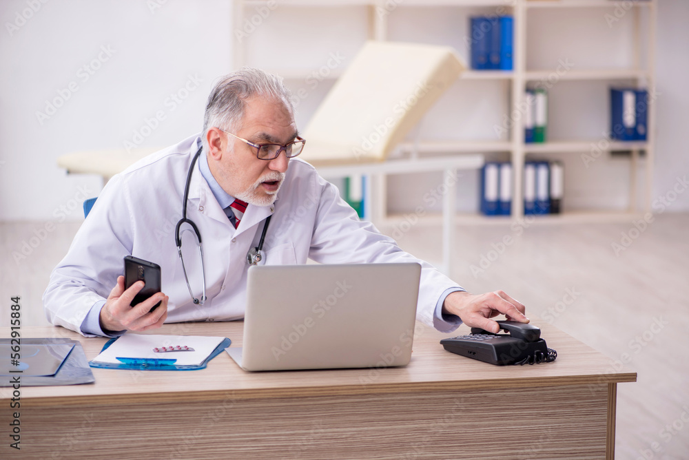 Old male doctor in telemedicine concept Old male doctor in telemedicine concept
