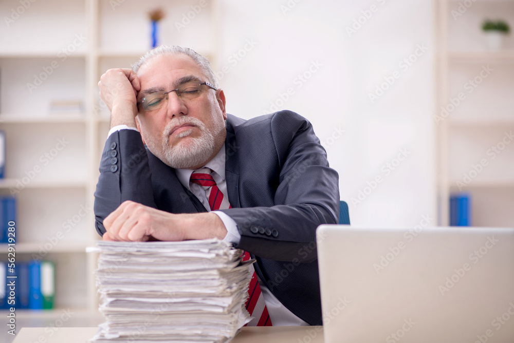Old male employee and too much work at workplace Old male employee and too much work at workplace