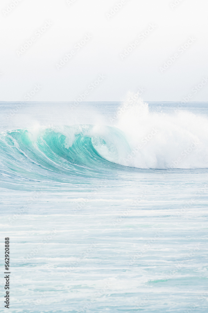 (Selective focus) Stunning view of some ocean waves breaking on the shore during a beautiful sunny day. Crushing waves, ocean waves relaxation. Bali, Indonesia.