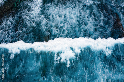 Obraz na płótnie Stunning aerial view of some ocean waves breaking on a blue sea. Crushing waves, ocean waves relaxation. Bali, Indonesia. w salonie