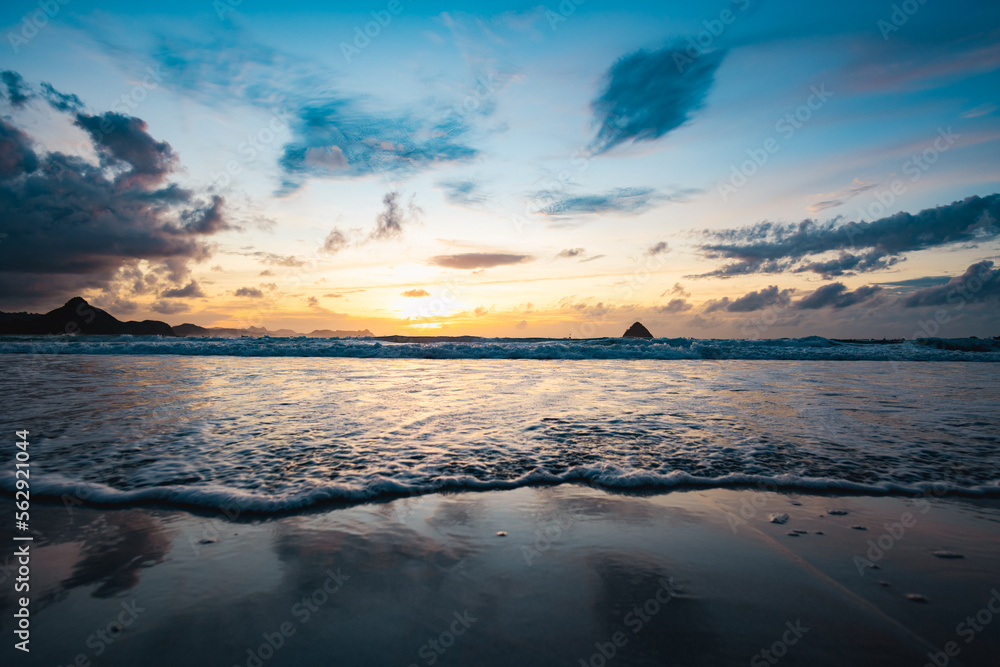 Stunning seascape with some waves crashing on a beach during a beautiful sunset. Lombok Island, West Nusa Tenggara, Indonesia.