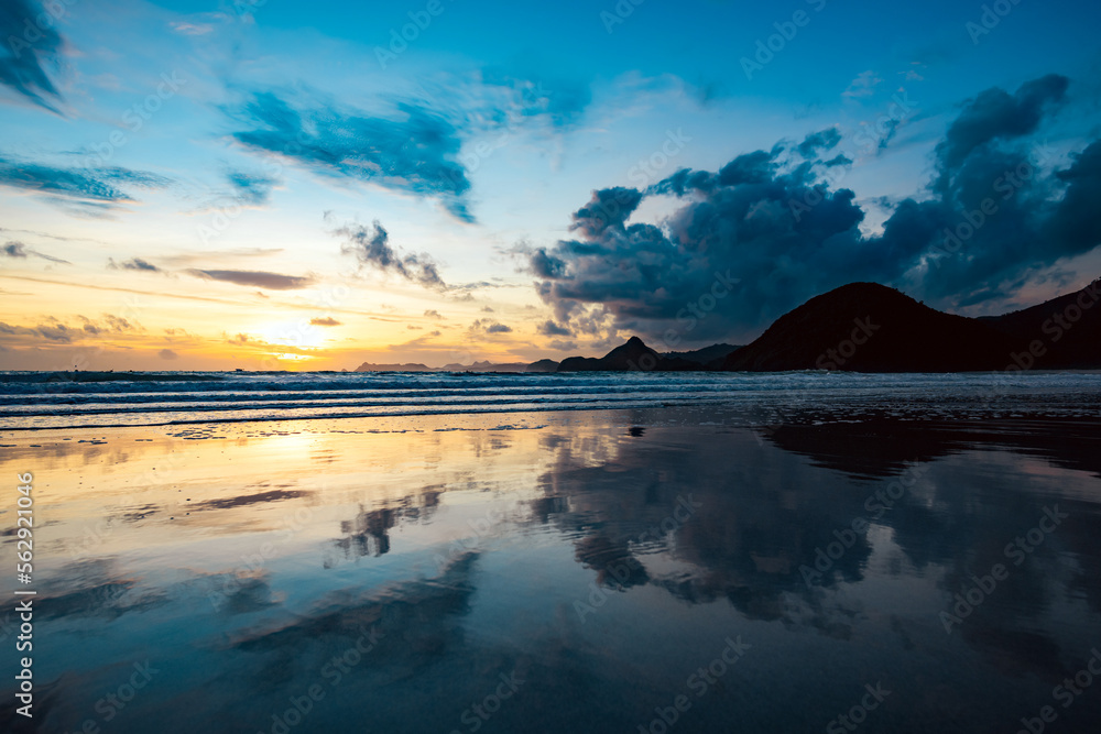 Stunning seascape with some waves crashing on a beach during a beautiful sunset. Lombok Island, West Nusa Tenggara, Indonesia.