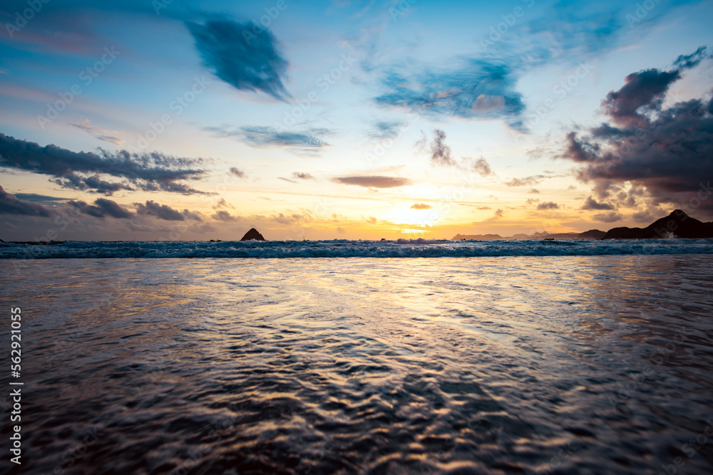 Stunning seascape with some waves crashing on a beach during a beautiful sunset. Lombok Island, West Nusa Tenggara, Indonesia.