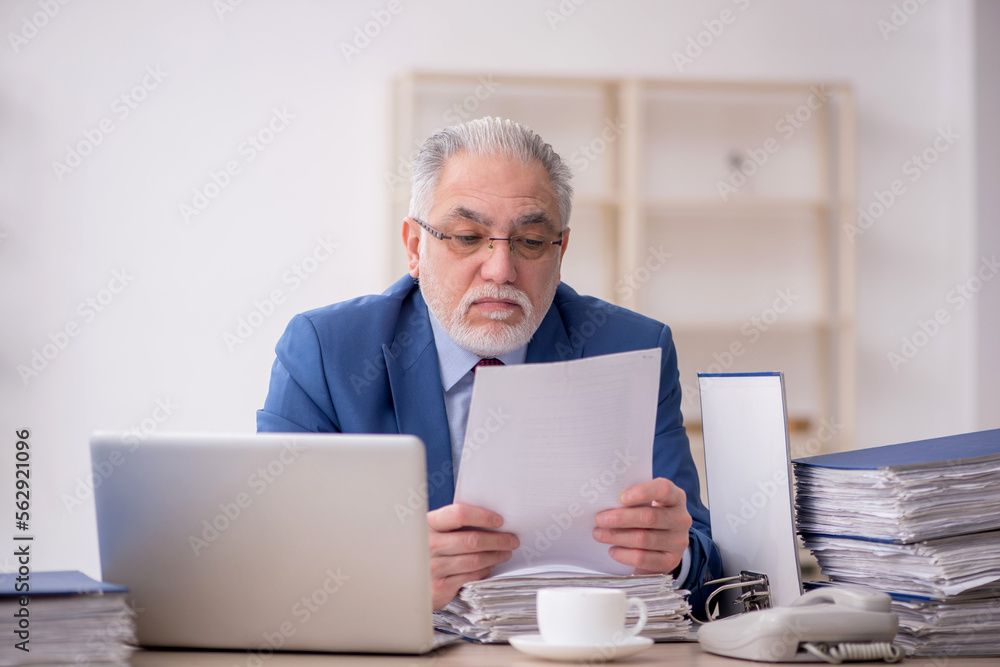 Old male employee and too much work at workplace Old male employee and too much work at workplace