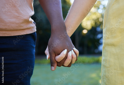 Interracial, couple holding hands and trust, love outdoor in nature and commitment, support in relationship. Together in park, black man with woman, hand zoom and care, romantic date with partnership