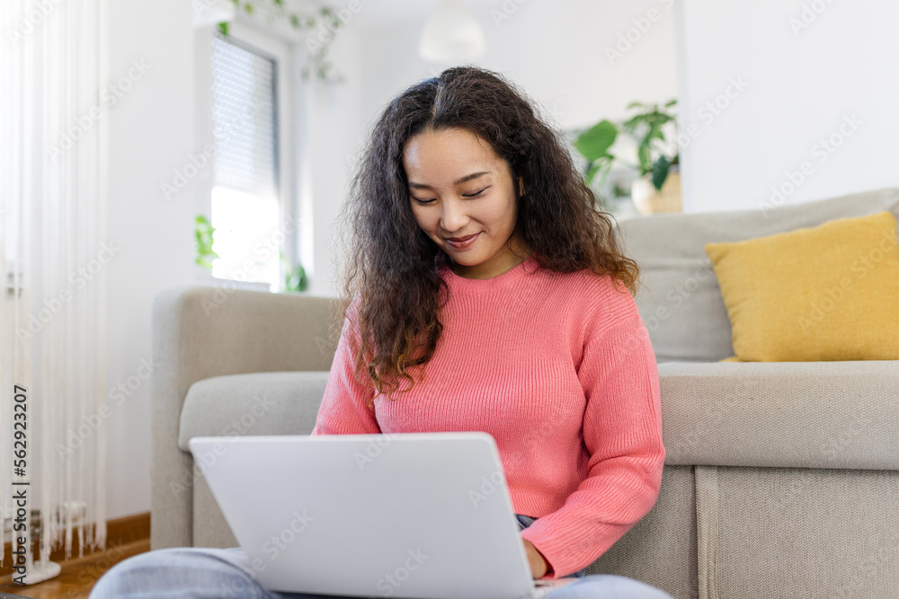 Asian woman sitting with computer on sofa, studying at home, e-learning and remote freelance job concept Asian woman sitting with computer on sofa, studying at home, e-learning and remote freelance job concept