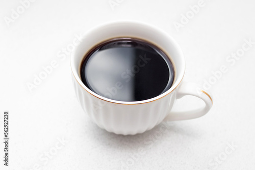 White cup of black coffee on white background