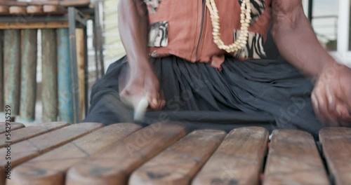 traditional african marimba player in traditional costume playing outdoors