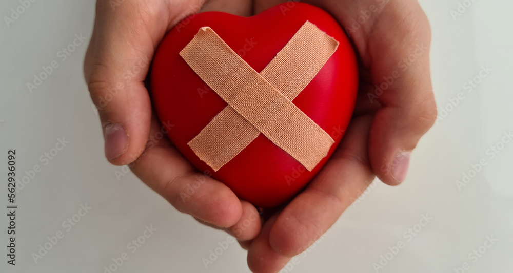 Wounded heart in children hands. Heart disease in children symptoms and treatment Wounded heart in children hands. Heart disease in children symptoms and treatment