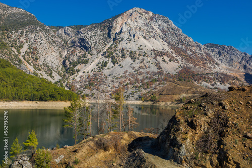 Dam lake in Green Canyon. Beatiful View to Taurus Mountains and turquoise water. Coniferous forest with green pine trees and a road stretching into the distance. Manavgat, Turkey.