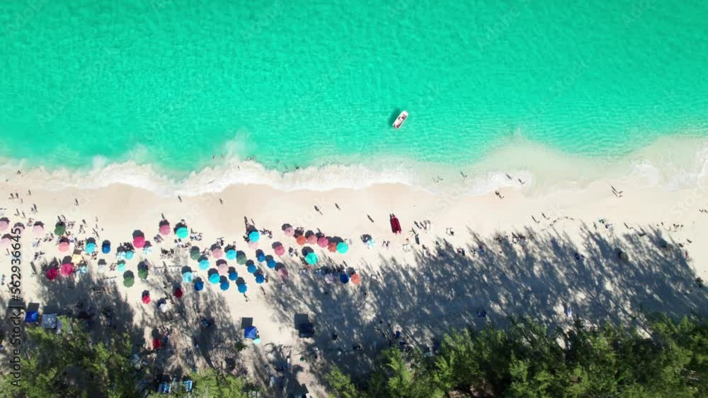 Overhead 4k drone clip of sandy beach with emerald water, crashing waves, colorful umbrellas. Overhead 4k drone clip of sandy beach with emerald water, crashing waves, colorful umbrellas.