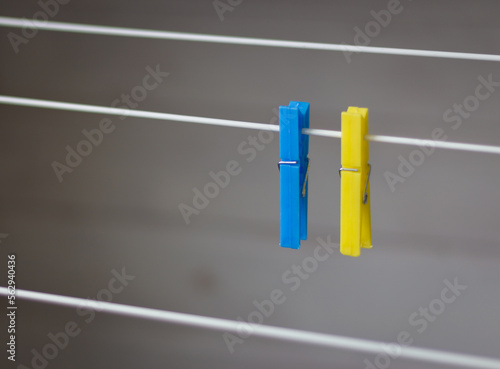 Clothing peg on washing line. Clothing pins on clothesline. Clothes pin in ukrainian colors. Blue and yellow pegs. Laundry concept. Household equipment. Ukrainian national colors. 