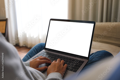 Foto Mockup image of a woman working and typing on laptop computer with blank screen