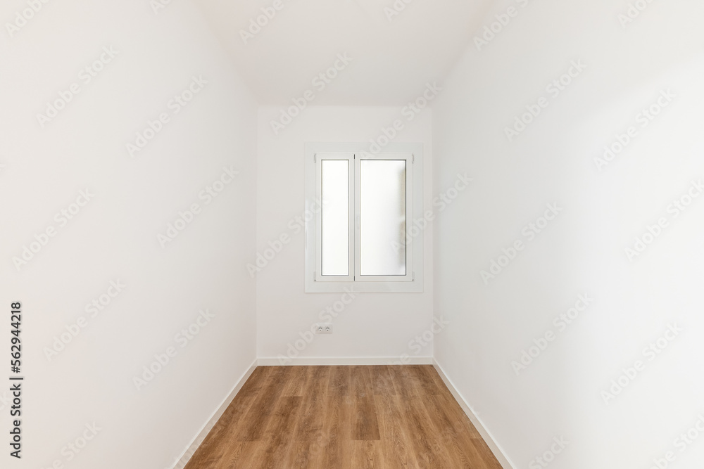Empty room with laminate flooring, newly painted white walls and bright window with frosted glass. Repair and construction concept. Empty room with laminate flooring, newly painted white walls and bright window with frosted glass. Repair and construction concept.