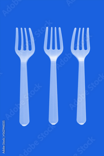 three plastic white forks on a blue background. isolate. Top view.