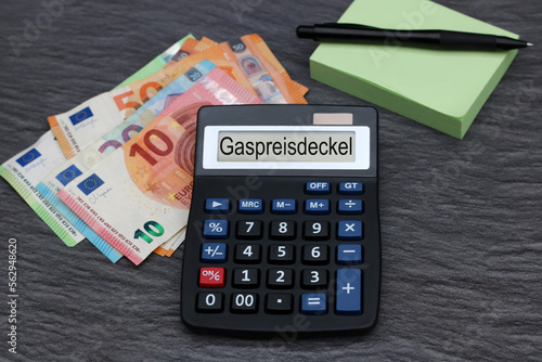 Das Wort Gaspreisdeckel ist auf dem Display eines Taschenrechners abgebildet mit Euro-Banknoten. 