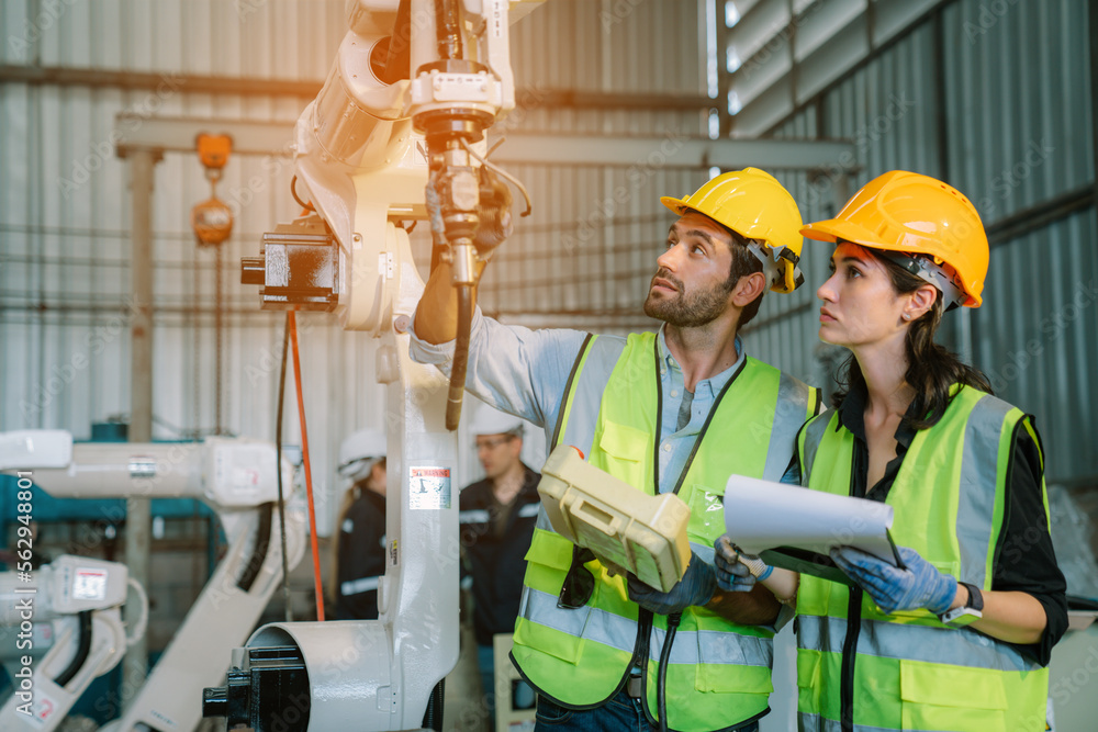 Foto de Team of Engineers is controlling robot arm machine welding