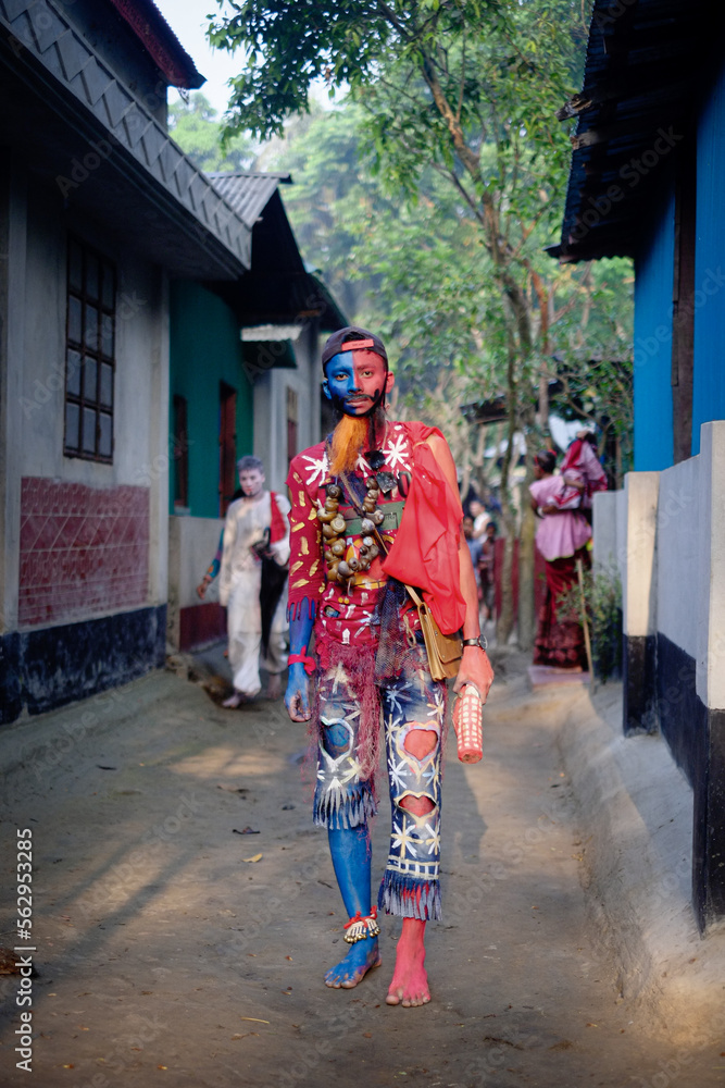 South asian young hindu religious boy wearing a wreath of dry snails and take makeup of a mad man in gajan festival South asian young hindu religious boy wearing a wreath of dry snails and take makeup of a mad man in gajan festival