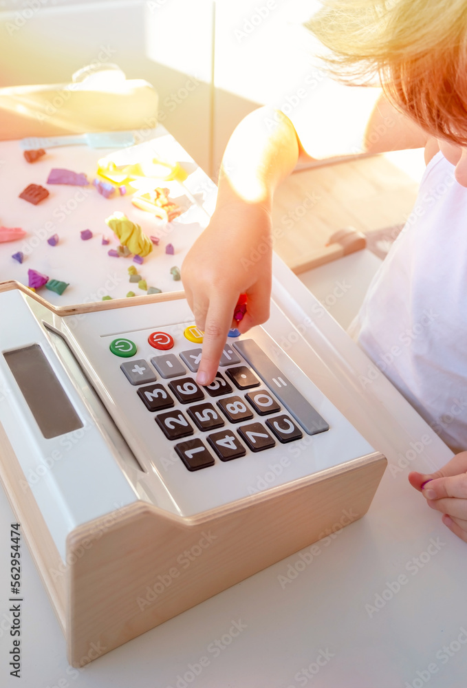 Close up of kid's finger is pressing to open the cash drawer toys in the play area. The concept of financial literacy of children Close up of kid's finger is pressing to open the cash drawer toys in the play area. The concept of financial literacy of children