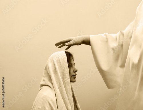 Blessing hand above the head of a woman in a headscarf