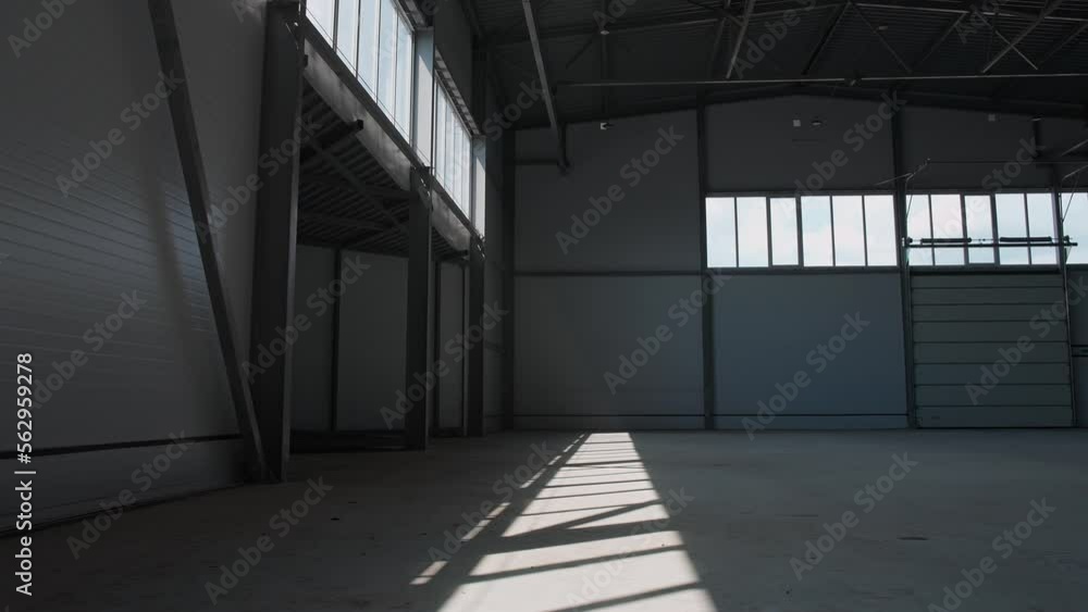 Hangar, industrial architecture, walking through the territory of an empty logistics warehouse, cinematic lighting. Hangar, industrial architecture, walking through the territory of an empty logistics warehouse, cinematic lighting.