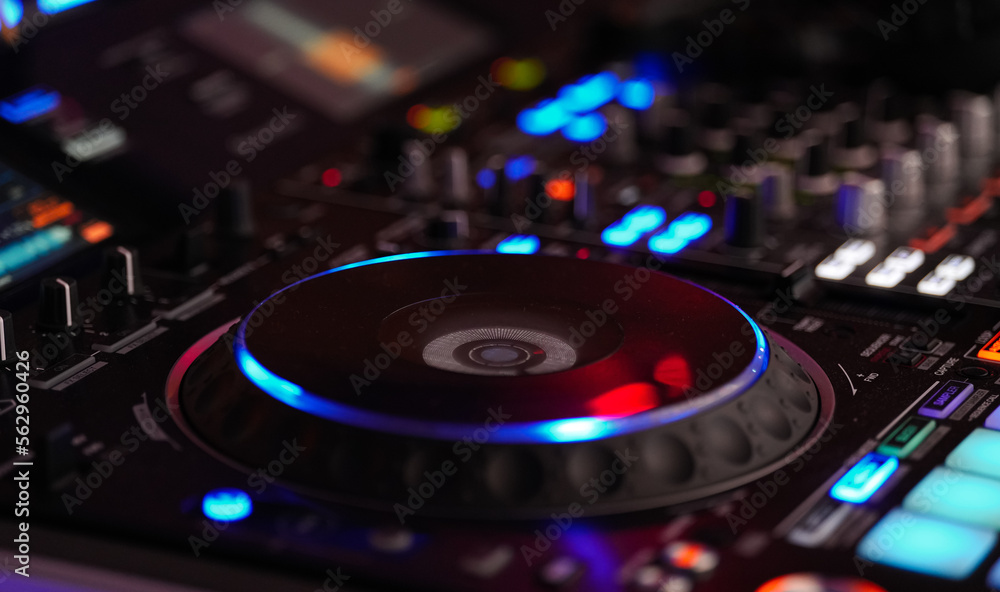 DJ mixing music audio equipment. Stage setup for the desk with disc mixer  where DJ put music for a party. Photos | Adobe Stock