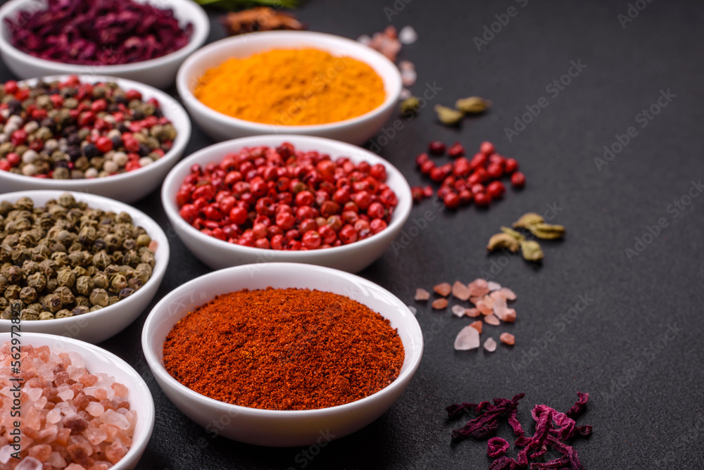 Composition consisting of variations of spices in white bowls and metal spoons