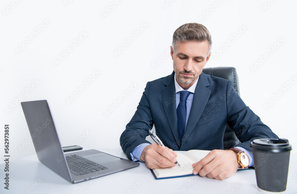 mature manager writing at the table in business office mature manager writing at the table in business office