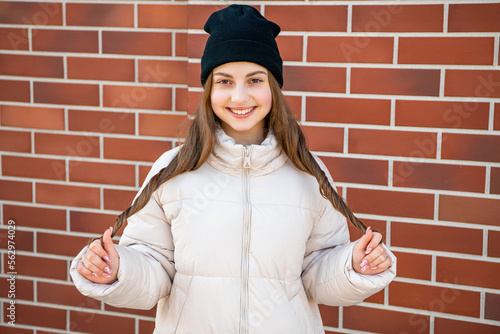 teenager girl having long hair outdoor. teenager girl wearing hat. photo of teenager girl outside