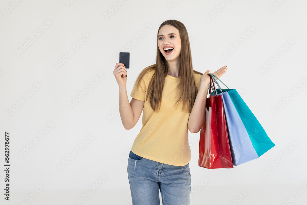 Portrait of a cheerful woman holding shopping bags and bank card on a white background Portrait of a cheerful woman holding shopping bags and bank card on a white background